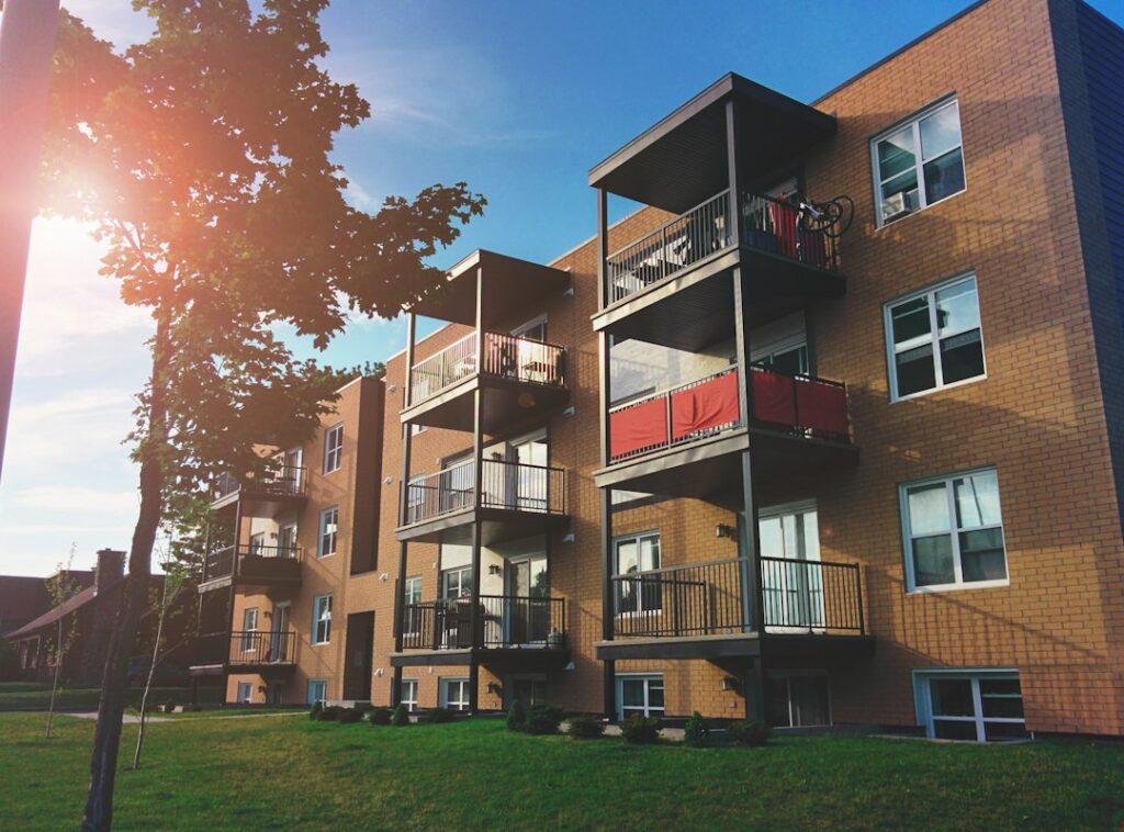 Exterior of a brown brick four-story apartment building with rows of windows