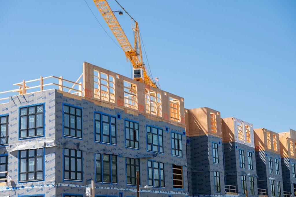 Building under construction with exposed structural framing, illustrating new multifamily development and housing supply