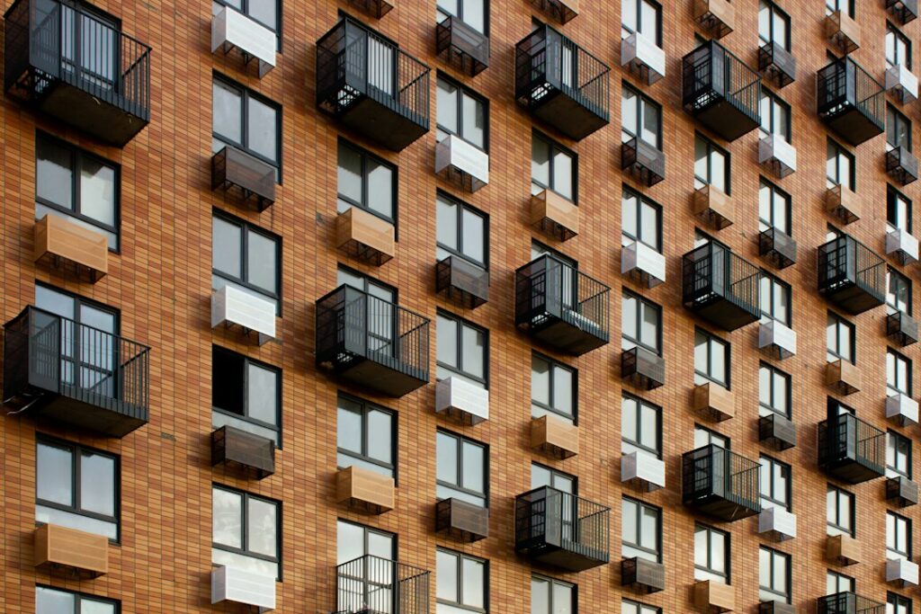 Facade of a mid-rise apartment building with rows of windows and private balconies
