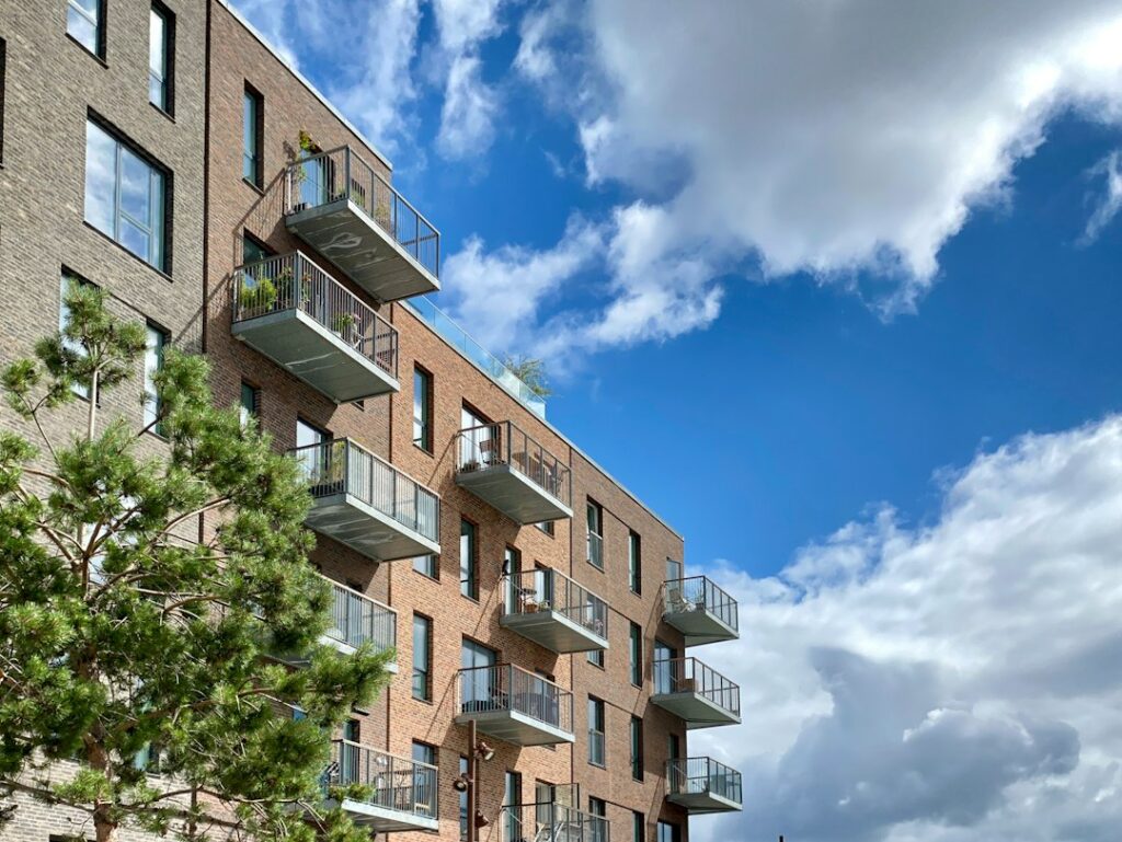 Exterior of a modern brick apartment housing complex with multiple stories of units
