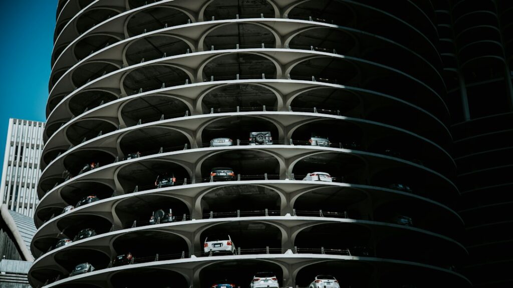 Multistory residential building exterior with cars parked along the street in front